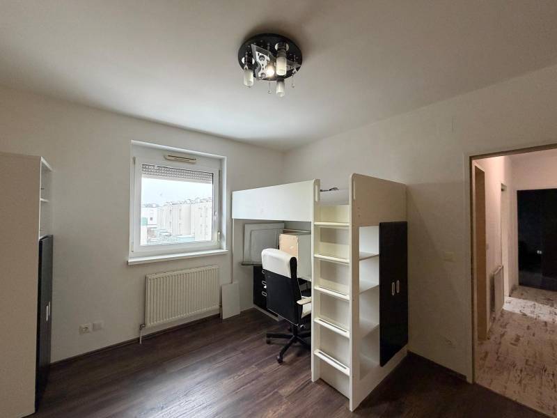 Gyerekszoba egy háromszobás lakásban emeletes ággyal és fa dekor padlóval.