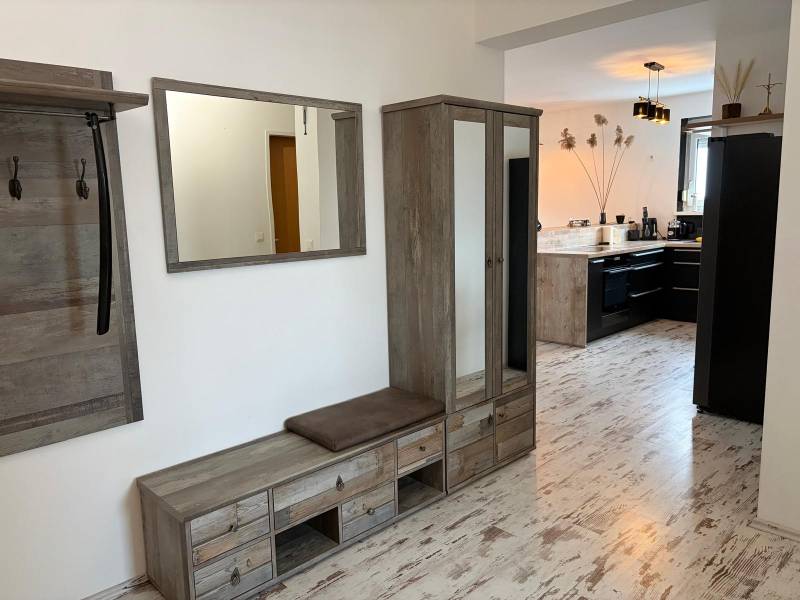 Előszoba fa dekorációval és kilátással a konyhára egy háromszobás lakásban.