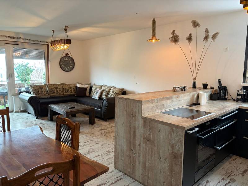 Konyha étkezővel egy háromszobás lakásban, fa dekoros padló, kényelmes kanapé.