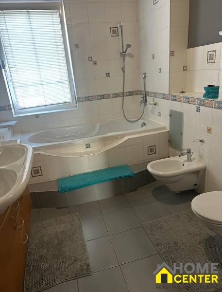 Fürdőszoba családi házban káddal, bidével és csempékkel.