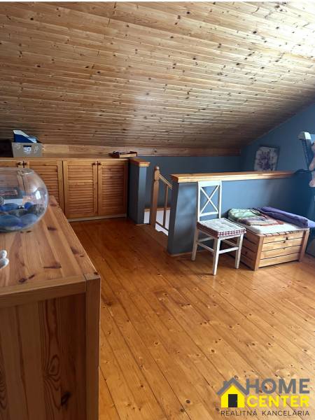 Családi ház tetőtér fa mennyezettel, falakkal és fa dekorációjú padlóval.