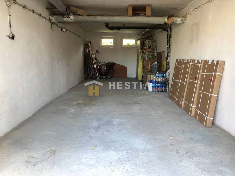 Garázs egy háromszobás lakásban tárolt tárgyakkal és kerékpárral.