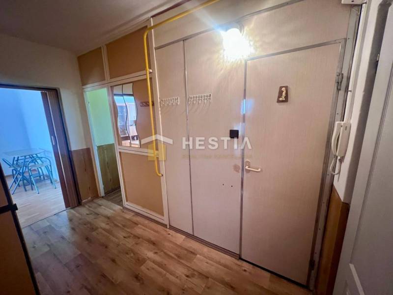 Folyosó egy 3 szobás lakásban fogassal, tükörrel és beltéri ajtókkal.