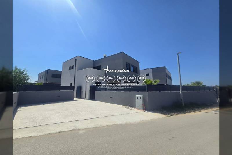 Villa a Zukve utcában, Vrsiben, nagy bejárati úttal és egyszerű homlokzattal.