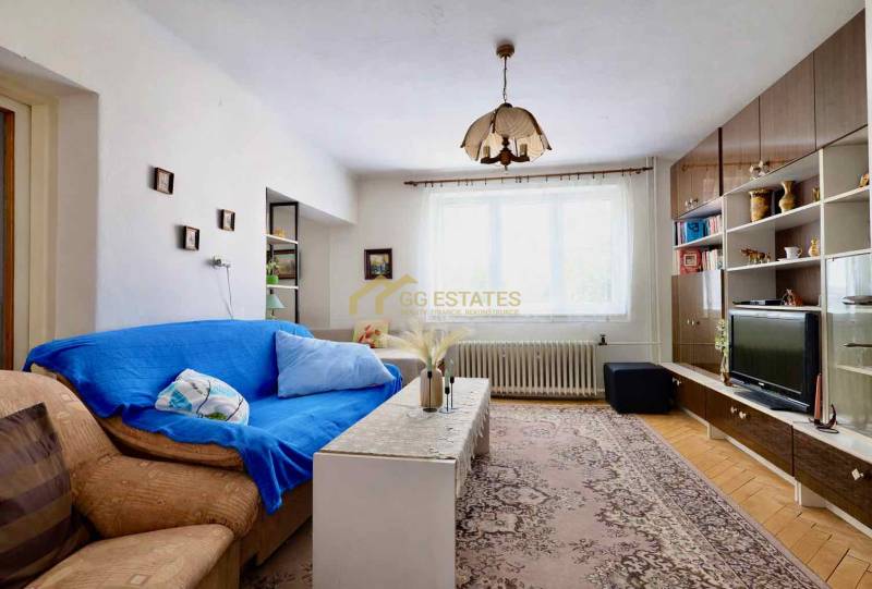 Nappali egy családi házban szőnyegmintával és bútorfallal.