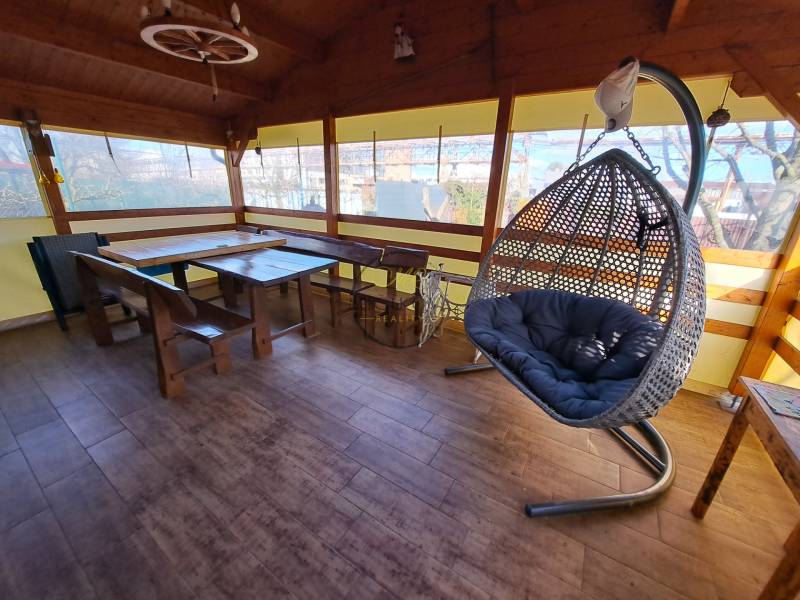 A nyugalom oázisa függőszékkel és fából készült bútorokkal, fa dekorációval a padlón a kertekben.