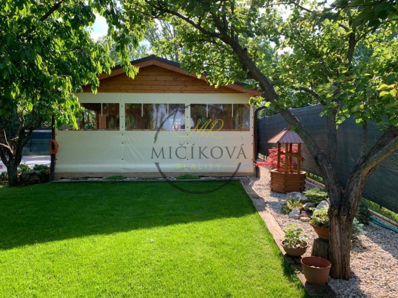 Kertek Alsókrškán, Nyitra, gyep, pavilon és fák.