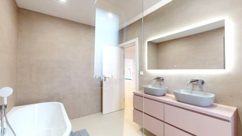 Fürdőszoba káddal, két mosdóval és tükörrel egy családi házban.