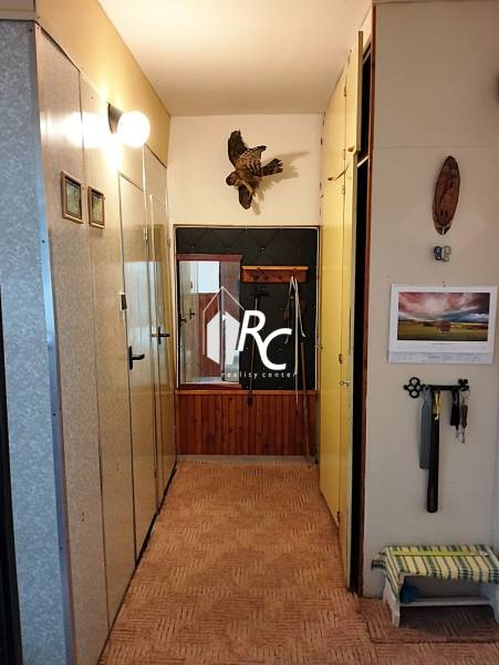 Folyosó egy 2 szobás lakásban fogasfallal és fali dekorációval.