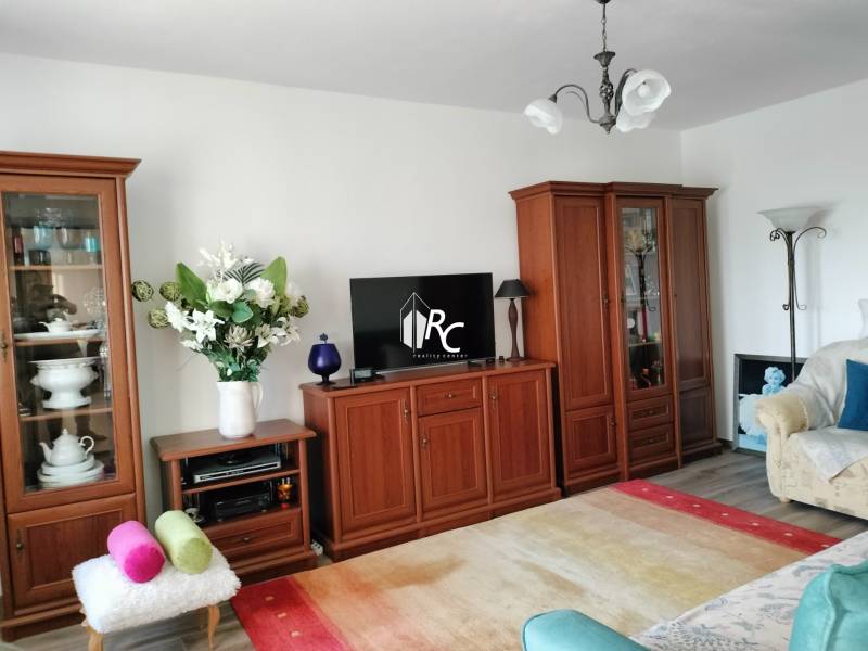 Nappali egy kétszobás lakásban, fa dekorációval és világos belső térrel.