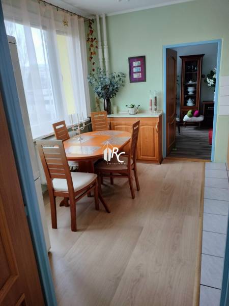 Étkező sarok egy kétszobás lakásban fa dekor padlóval és világos bútorokkal.