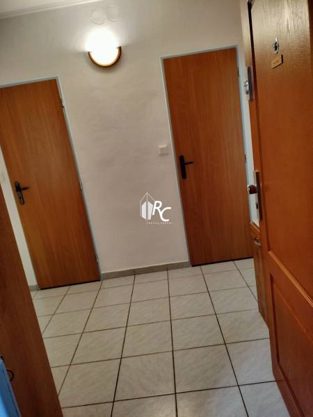 Előszoba egy kétszobás lakásban csempével és faajtókkal.