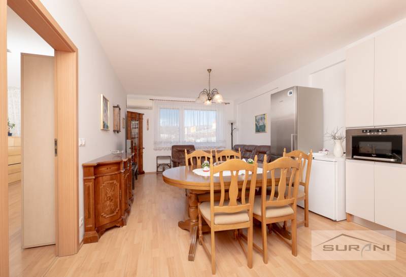 Ebédlő fa dekorációjú padlóval és bútorokkal egy háromszobás lakásban.