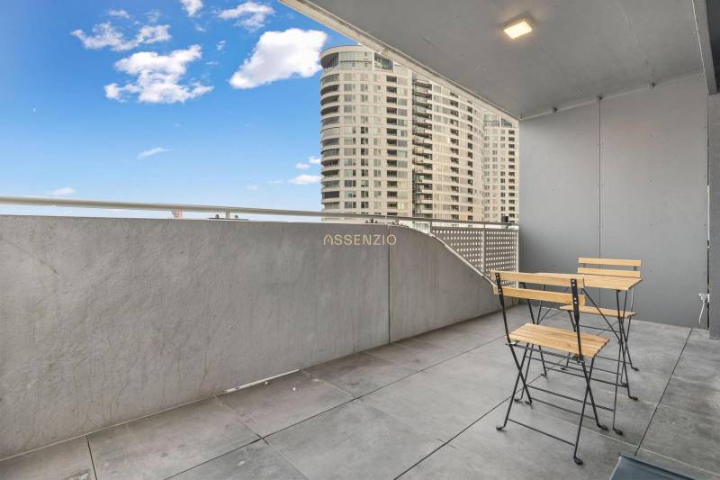 Erkély modern bútorokkal, kilátással a magas épületekre Pozsony - Újvárosban.