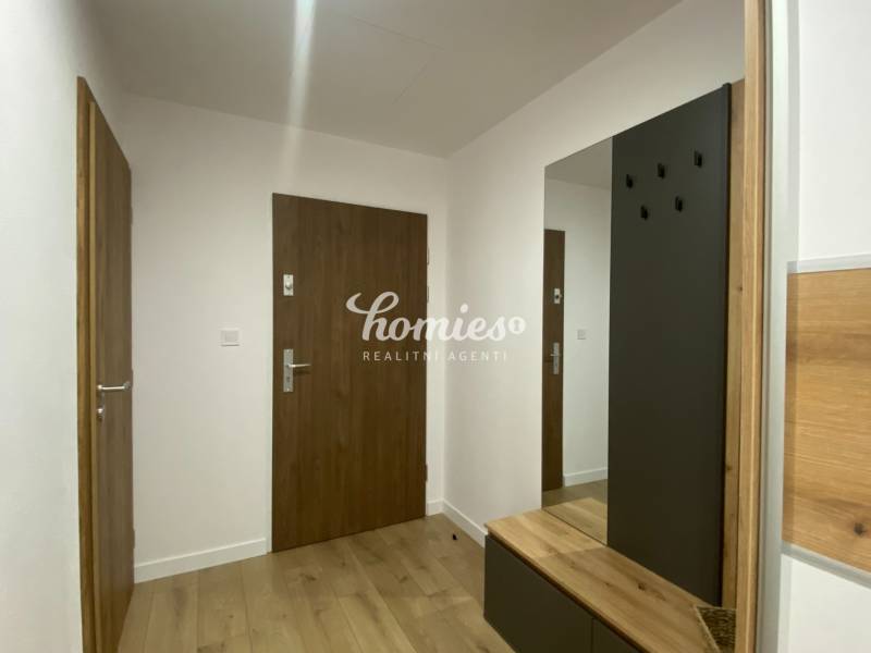 2 szobás lakás folyosója fa dekor padlóval és beépített szekrénnyel.