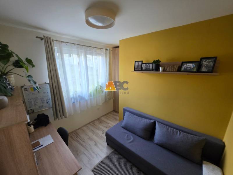 Szoba családi házban, fa dekorációs padlóval, íróasztallal és kanapéval.