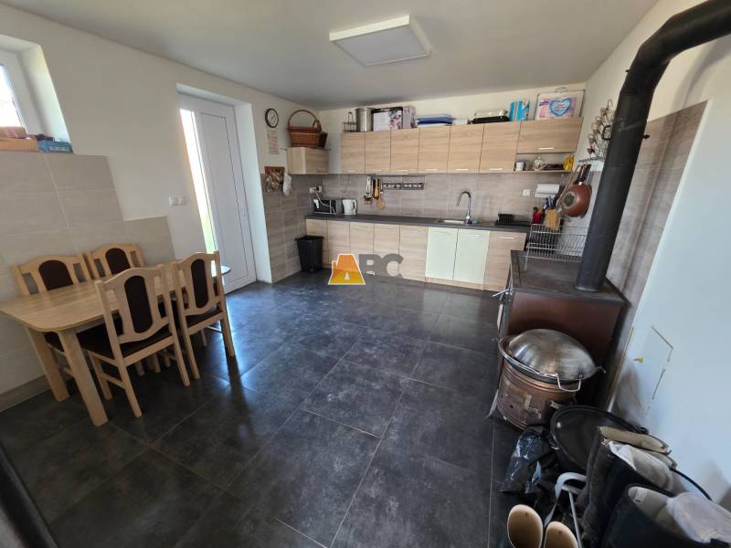 Családi ház konyhája konyhabútorral, étkezőasztallal és tűzhellyel.