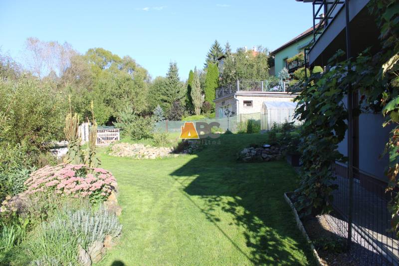 Családi ház kertje a Lukavica Lipová utcájában, zölddel és virágokkal körülvéve.