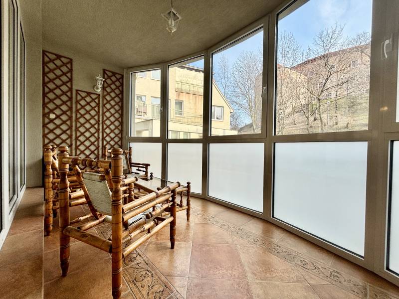 A 4 szobás lakás tipikus télikertje rattan bútorokkal és nagy ablakokkal rendelkezik.