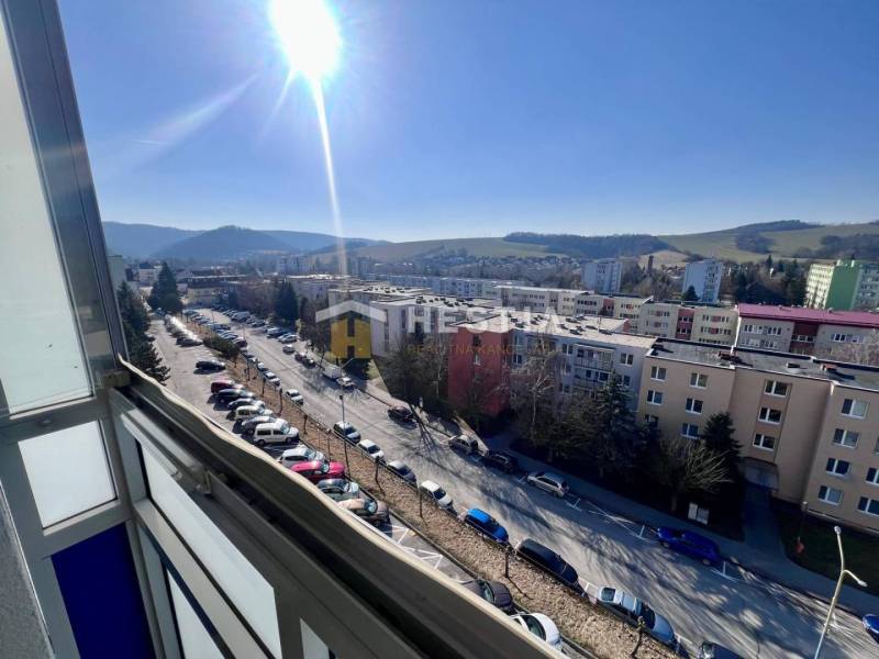 Kilátás egy háromszobás lakásból Brezová pod Bradlom városában a lakótelepre és a környező tájra.