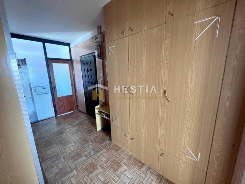 Folyosó egy 3 szobás lakásban, szekrénnyel és fa dekorációjú padlóval.