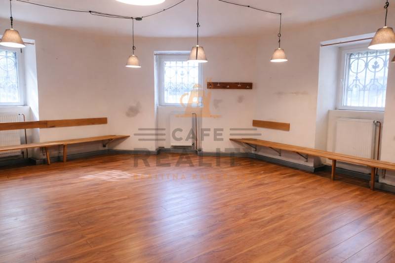 Üzlethelyiség fa dekorációjú falakkal, padokkal és padlóval, függőlámpákkal megvilágítva.