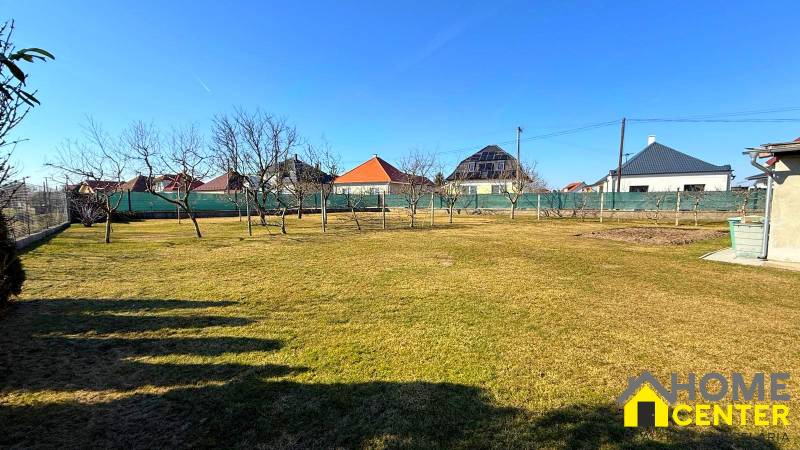 A Zemianska Olča családi házának kertje gyepes és gyümölcsfákkal van beültetve.