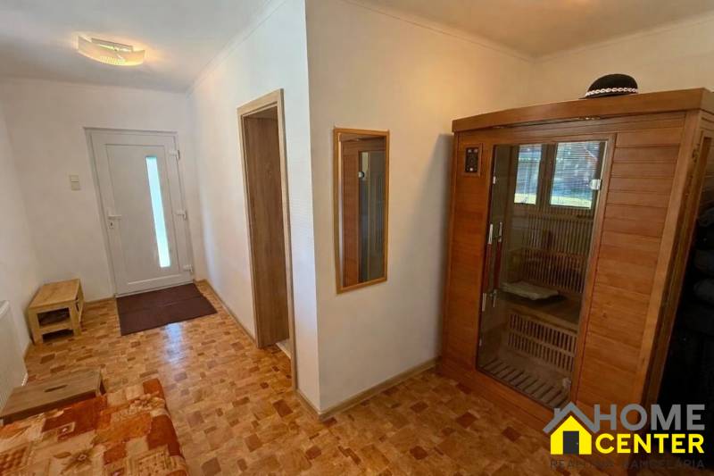 Egy családi ház folyosója fa dekorációs padlóval és beépített szaunával.