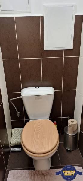 WC fa hatású padlóval egy 4 szobás lakásban.
