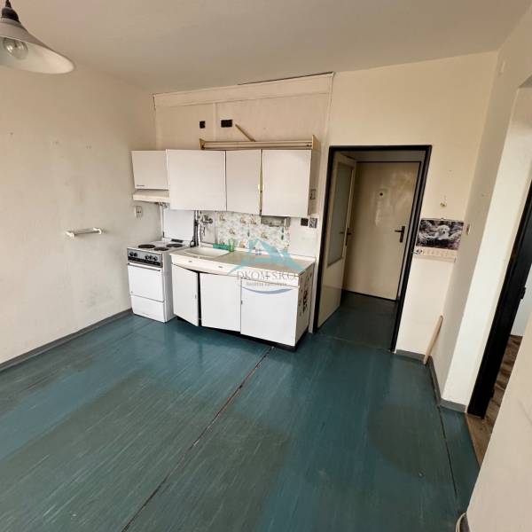 Konyhaszekrény egy egyszobás lakásban, fa dekorációjú padlóval.