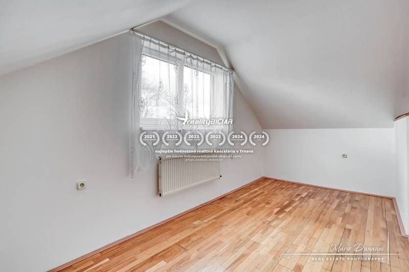 Szoba egy családi házban, ablakkal és fa dekorációjú padlóval.