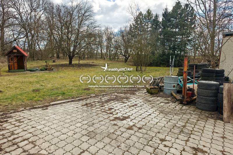 Pavlice, családi ház Pavlicén térkövezett udvarral, fészerrel és egy halom gumival.