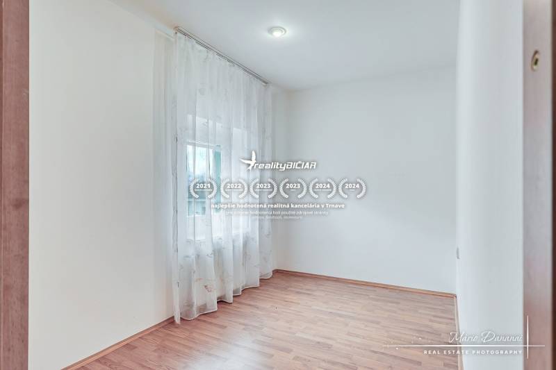 Világos szoba fa mintás padlóval és függönyökkel egy családi házban.