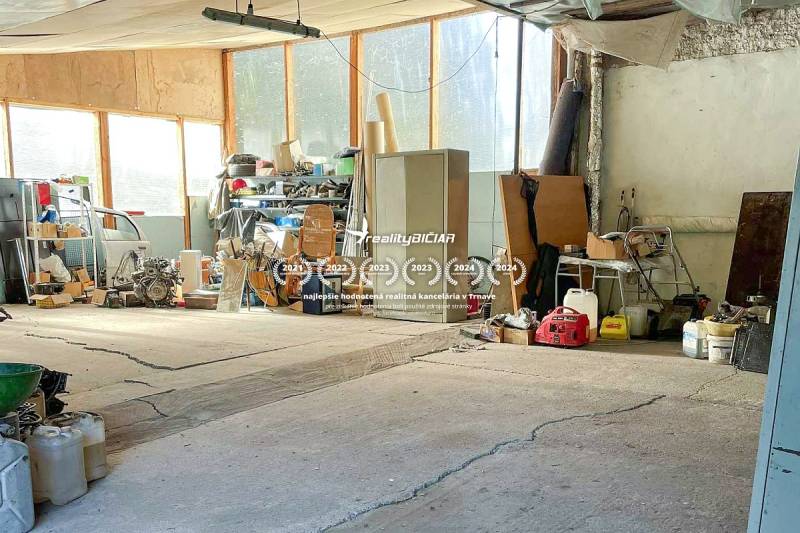 Családi ház garázsa tele szerszámokkal és gépekkel, különféle felszerelésekkel a polcokon.