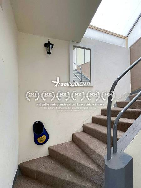 Családi ház lépcsője fehér falakkal és fém korláttal.