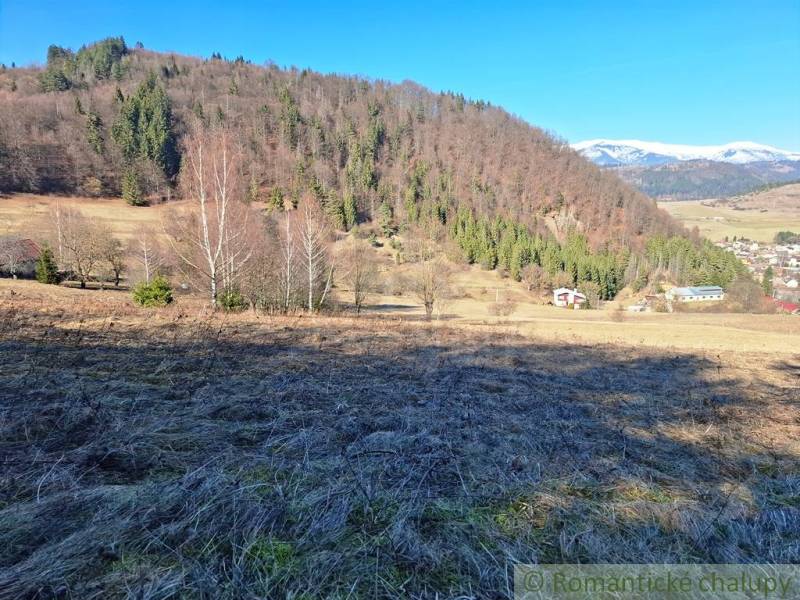 Kilátás a lakóövezeti telkekre Hroncban, háttérben erdőkkel és hegyekkel.