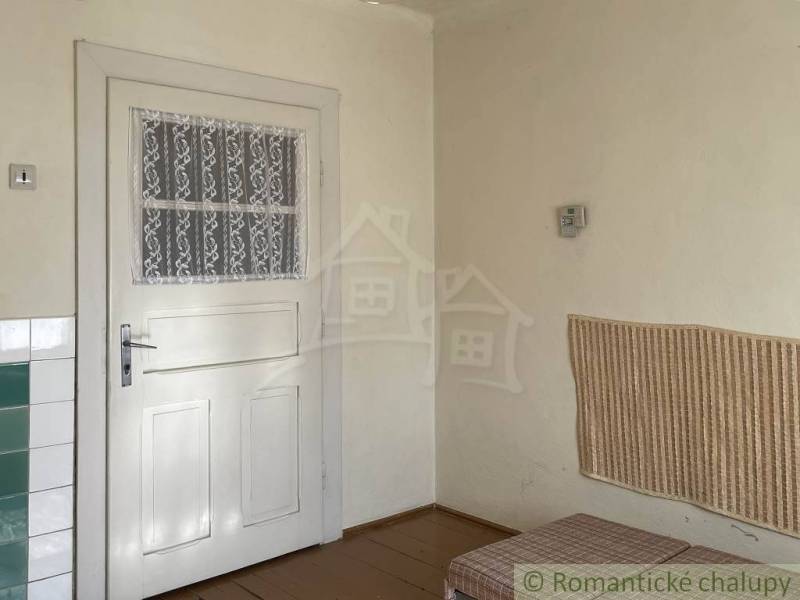 Családi ház belső tere fehér ajtókkal, fa dekorációjú burkolattal és padlóval.