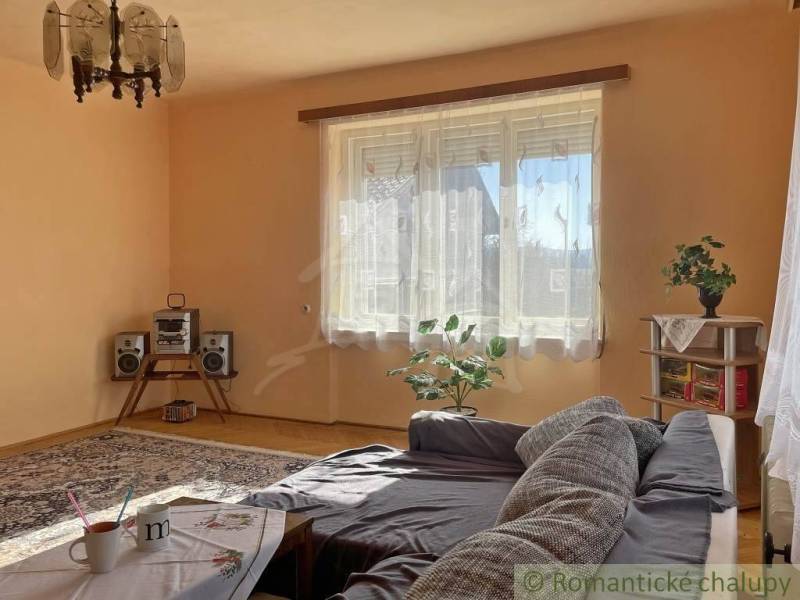 Nappali egy családi házban kanapéval, szőnyegekkel és hi-fi berendezéssel.