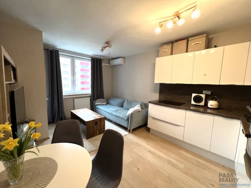 Konyha és nappali egy kétszobás lakásban fa dekor padlóval.