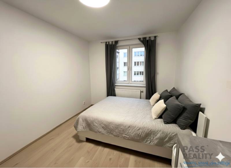 Hálószoba ággyal és fa dekorációjú padlóval egy kétszobás lakásban.