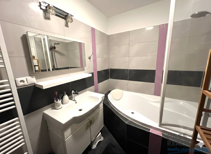 Fürdőszoba káddal, mosdóval és tükörrel egy kétszobás lakásban.