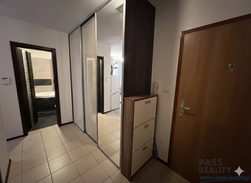 Előszoba egy kétszobás lakásban csempével, nagy tükörrel és szekrényekkel.