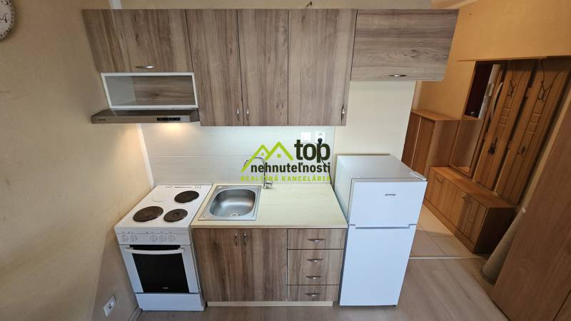 Konyha a garzonlakásban fa dekor padlóval és alapfelszereltséggel.