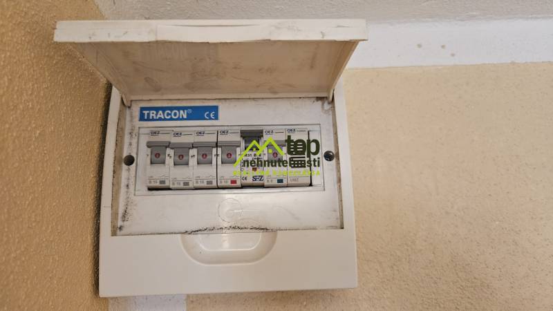 Elektromos elosztószekrény biztosítékokkal a garzonlakásban, falra szerelve fedéllel.