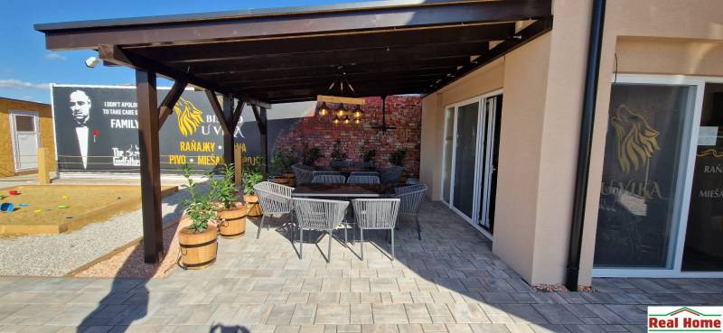 Újfalusi vendéglátóhelyek kültéri ülőhellyel és téglafallal.