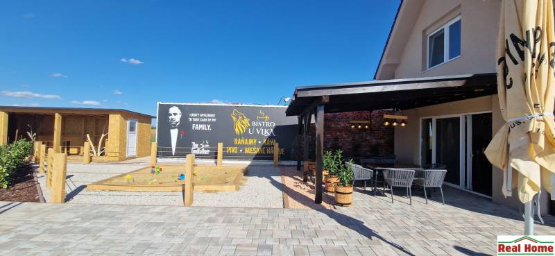 Vendéglátóhelyek Újfaluban terasszal, homokozóval és tematikus kilátással.