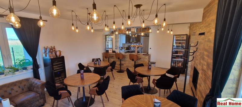 Vendéglátóhely belső terei fa dekorációjú padlóval és izzólámpás világítással.