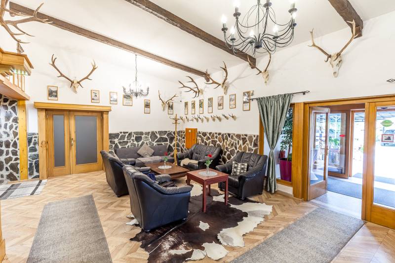 Egy rekreációs apartman belső tere bőr ülőgarnitúrával, sarokkal és fa dekorációjú padlóval.