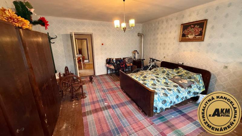 Szoba egy családi házban hagyományos ággyal, ruhásszekrénnyel és kerékpárral.