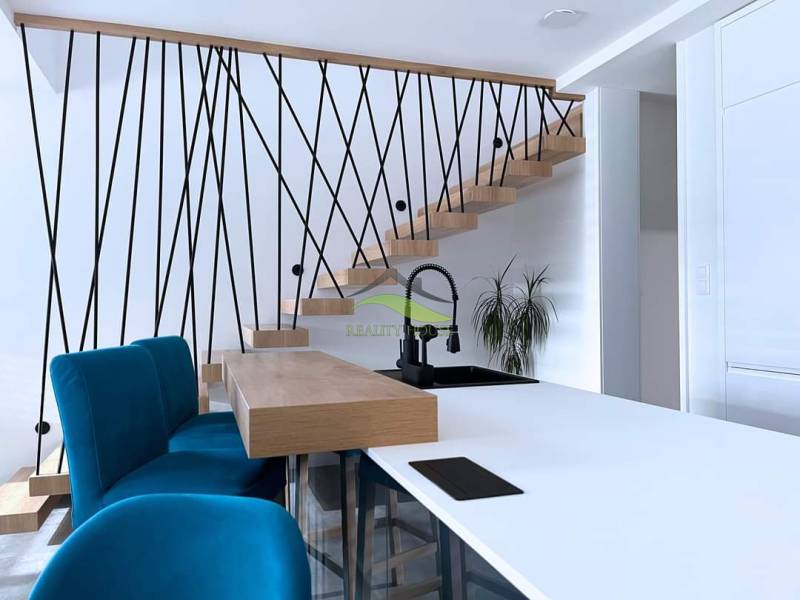 Családi ház belső tere lépcsővel, kék székekkel és konyhapulttal.